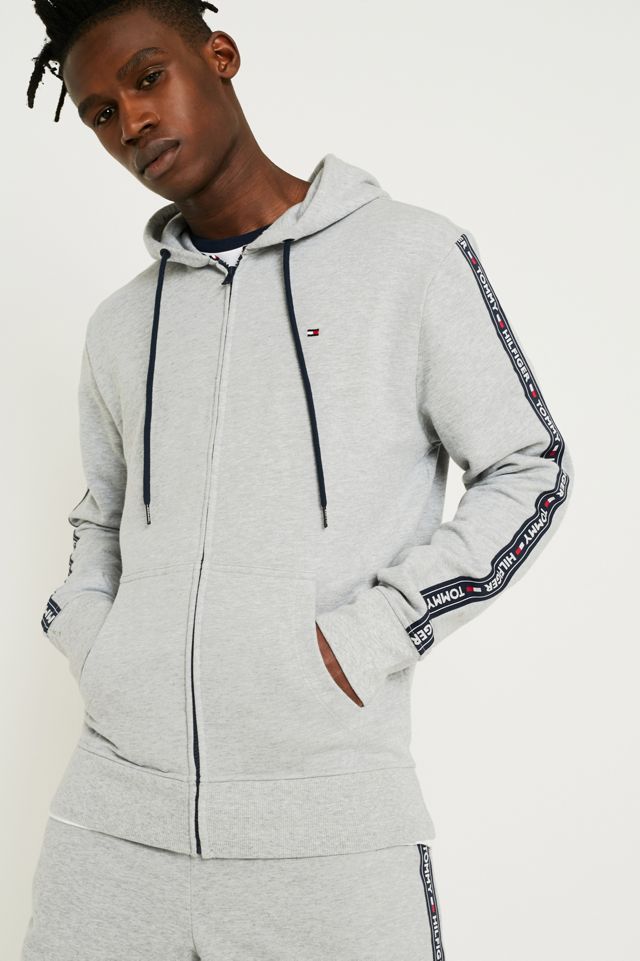 Tommy Hilfiger Hoodie in Grau mit Logostreifen auf den Armeln Urban Outfitters DE
