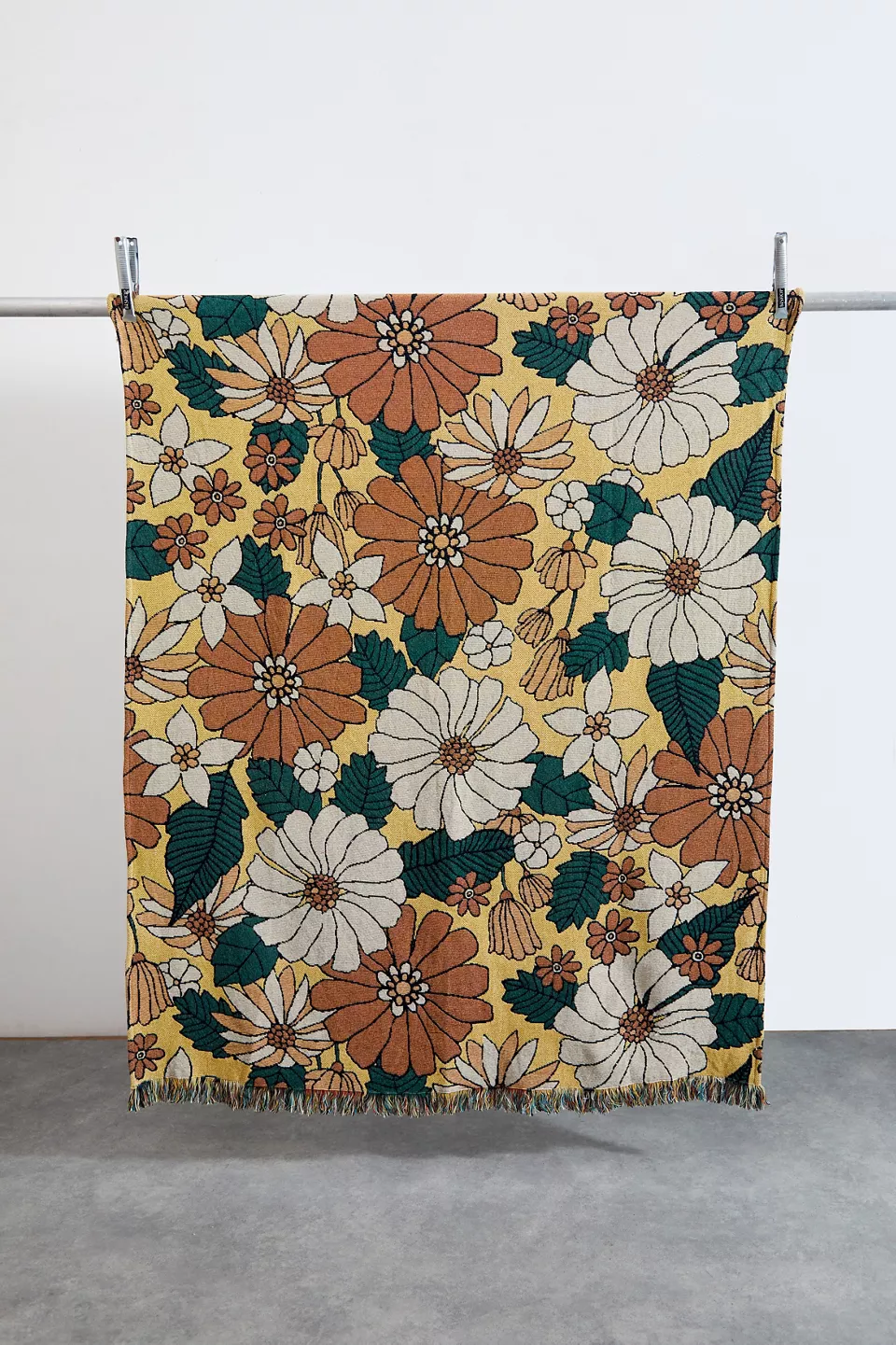 A floral blanket hanging on a bar